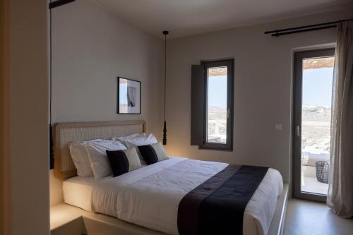 超级天堂海滩Nimbus Lumen的一间卧室设有一张大床和两个窗户。