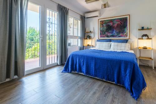 米哈斯科斯塔La Ponderosa 5的一间卧室配有一张带蓝色床罩的床
