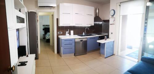 马里诺Delizioso appartamento nel cuore Castelli Romani的厨房配有白色橱柜和蓝色家电