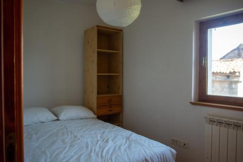 DutovljeApartma Na skdnu的一间卧室设有一张床和一个窗口