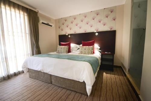 开普敦信号山旅舍的酒店客房配有一张带红色枕头的大床