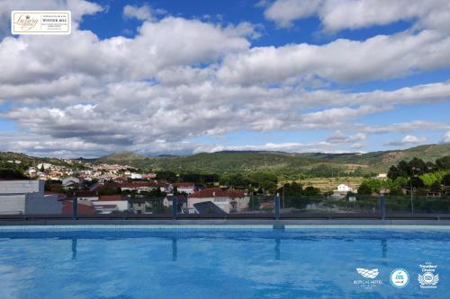 博蒂卡什博蒂卡斯艺术和SPA酒店的一个大游泳池,后面有一个城市