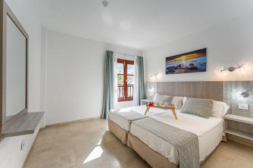 洛斯克里斯蒂亚诺斯Klayman Olivina Aparthotel的卧室设有一张白色大床和一扇窗户。