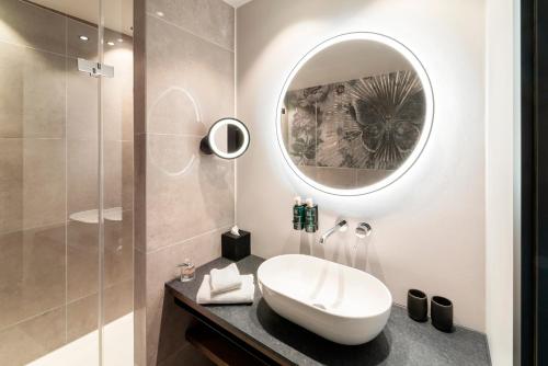 拉芬斯堡Hotel Kaiserhof Ravensburg的一间带水槽和镜子的浴室