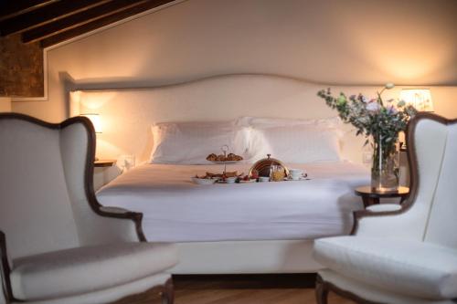 佩斯基耶拉德加达乐阿里弗拉西诺酒店的卧室配有白色的床和两把椅子