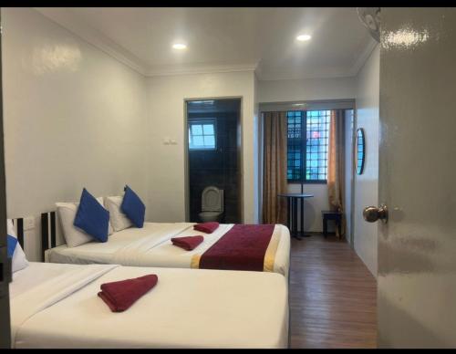 丹那拉打ESM Hotel的一间酒店客房,设有两张床和一扇门