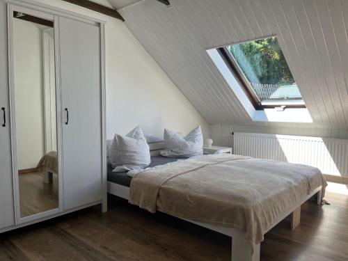 柯尼希施泰因易北Saechsische-Schweiz-Ferienhaus-Wohnung-1-mit-Elbblick-Sauna-und-Kamin的卧室配有带枕头的床铺和窗户。