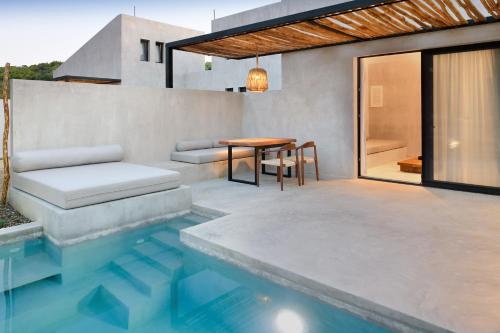 奥马斯帕纳吉亚斯Pure Villas的一个带桌子和游泳池的庭院