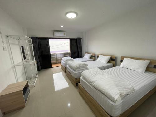 合艾Khoksametchun Hostel Plus 2的一间卧室配有两张床和电视。