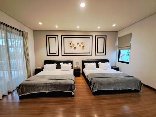Gadok 1THE OASIS 4BR Private Pool Pet-Friendly Villa Vimala Hills的一间卧室设有两张床和大窗户
