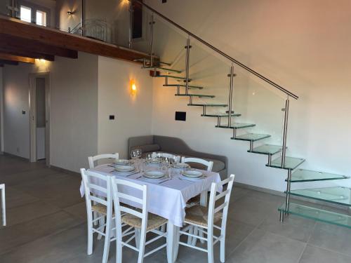 TerguVilla Infinity的一间带白色椅子和楼梯的用餐室
