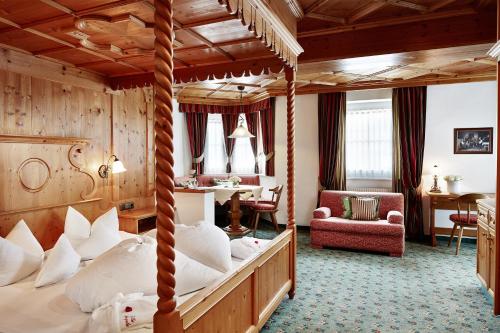 迈尔霍芬安吉拉别墅酒店的一间带天蓬床的卧室和一间客厅