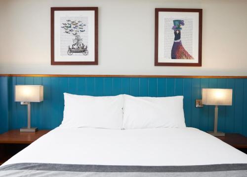邓斯特布尔海维曼酒店的一间卧室配有一张大床和两盏灯