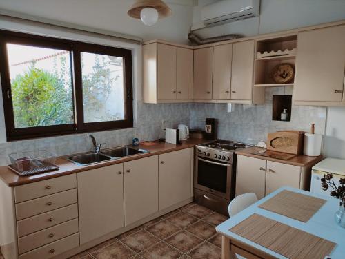 PaianíaCozy apartment in Peania (near Airport)的厨房配有白色橱柜、水槽和炉灶。