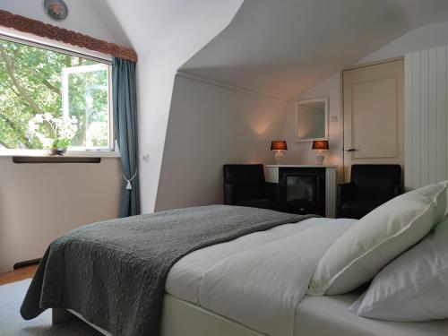 斯希丹B&B Hotel Elselina的一间卧室配有一张带两把椅子的床和一扇窗户