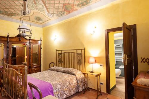SassoferratoDegli Alessandri Palace的一间卧室配有一张床,浴室设有浴缸