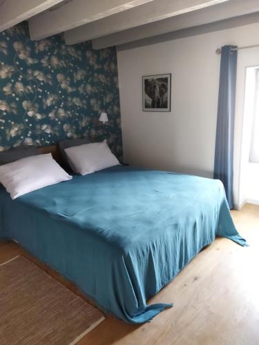 LierguesLa ferme du vincent的一间卧室配有一张带蓝色毯子的床