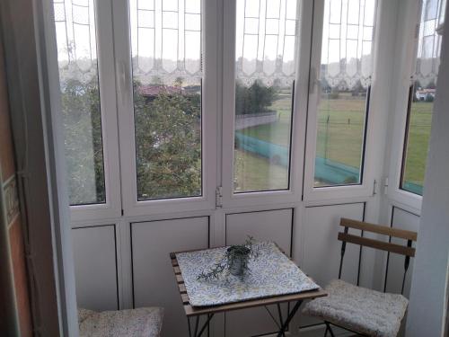 MonteCasa Bayona的客房设有桌子、两把椅子和窗户。