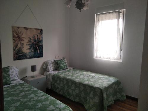 MonteCasa Bayona的一间卧室设有两张床和窗户。
