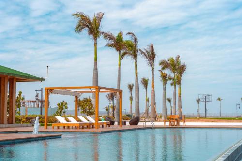 普拉亚斯Karibao Resort Town的一个带躺椅的游泳池,棕榈树