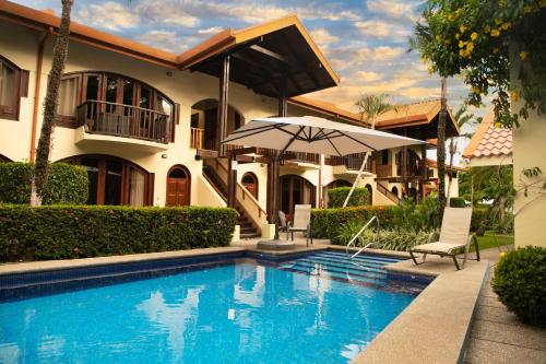 雅科Apartotel Girasol的一座带游泳池和遮阳伞的房子
