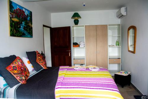 勒穆莱Villa Prunepassion的一间卧室配有一张带彩色毯子的床