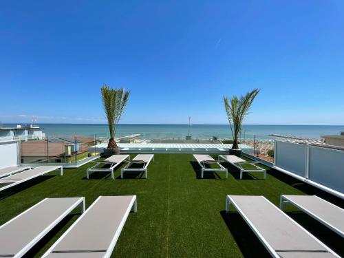 卡奥莱MAR60 Apartments的一个带长椅的庭院和背景海洋