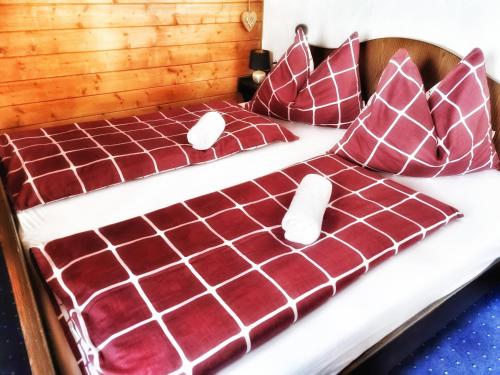 索内纳尔佩·纳斯费尔德das Bergerleben的一张铺有红白色床单和枕头的床