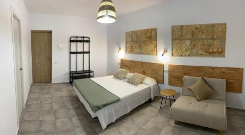 阿尔库迪亚港Hostal Residencia Alma的一间卧室配有一张床和一把椅子