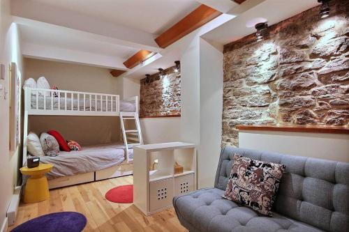 魁北克市GENERATIONS QUEBEC OLD CITY/ Parking/ Family的客房设有双层床和岩石墙。