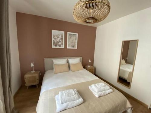 贝莱姆L'Ilot du Perche: Appartement cosy avec jardin的一间卧室配有一张床,上面有两条毛巾
