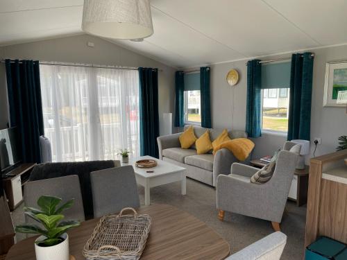 Belton6 Berth Comfy Homely Caravan, Dog Friendly的客厅配有沙发、椅子和桌子