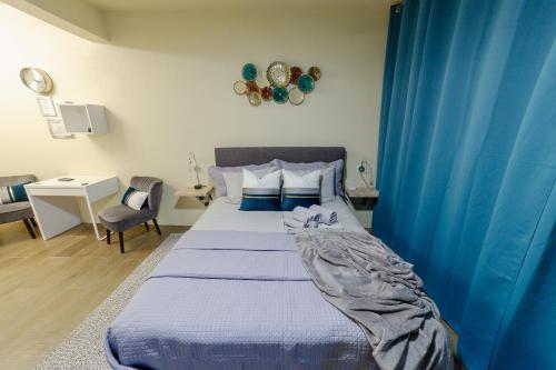 George HillLittleLux Living的一间卧室配有一张蓝色窗帘的床