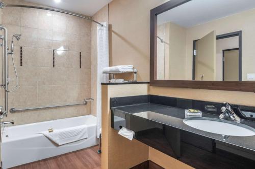 巴瑟斯特贝斯特韦斯特PLUS巴瑟斯特酒店及套房的一间带水槽、浴缸和镜子的浴室