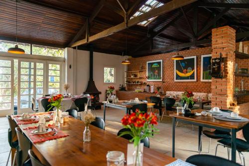 布拉干萨-保利斯塔Pousada Recanto das Rosas的一间在房间内配有桌椅的餐厅
