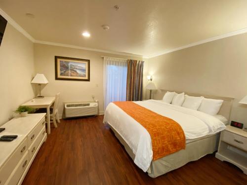 滨海城Monarch Valley Inn Marina at Monterey Bay的酒店客房设有一张大床和一张书桌。