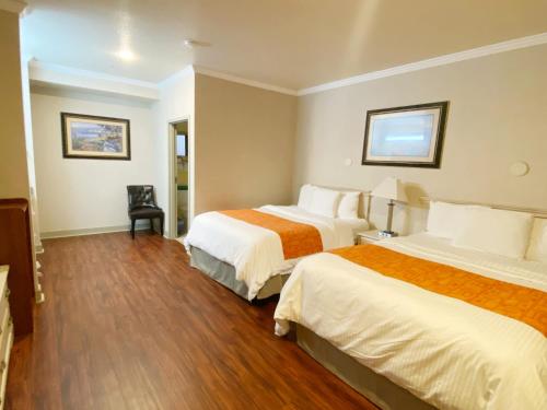 滨海城Monarch Valley Inn Marina at Monterey Bay的酒店客房,配有两张床和椅子