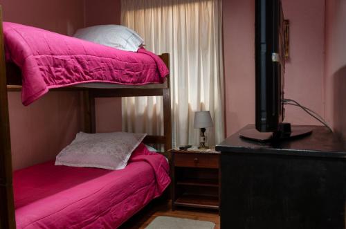 特木科Hostal Sol Temuco的一间卧室配有带粉红色床单的双层床