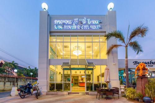 北碧Kanchanaburi City Hotel - SHA Extra Plus的停在前面的一座带摩托车的建筑