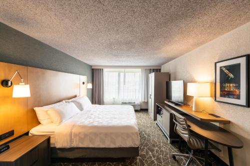 纽瓦克Holiday Inn Newark International Airport的配有一张床和一张书桌的酒店客房