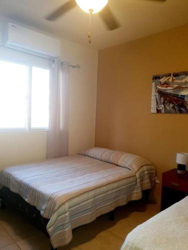 圣佩德罗苏拉Hermoso Apartamento的一间卧室设有两张床和窗户。