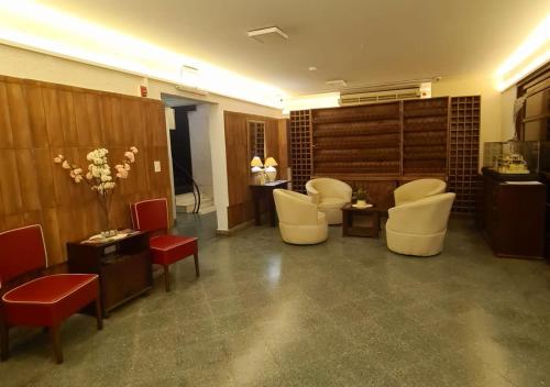 亚松森Hotel Hassler的一间设有白色椅子的等候室和一个沙龙