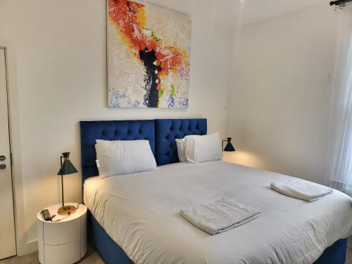芬奇利Garland Modern 4 Bedroom Central Apartment London的卧室里一张带蓝色床头板的床