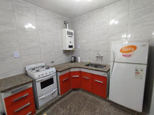 圣米格尔·德·图库玛Casa Barrio Sur COMODA的小厨房配有白色冰箱和红色橱柜