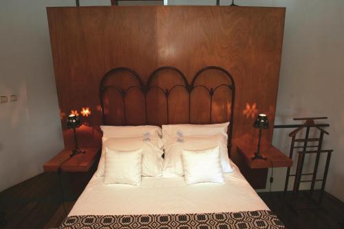 七城奥姆胡达比比度假屋的一张带木制床头板和白色枕头的床