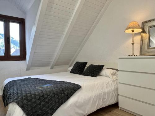 萨连特加列戈Locky · Espacio y Exclusividad ❅ Pirineos360 ❅的卧室配有带黑色枕头的白色床