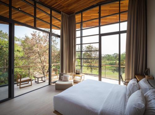 慕斯Gliding Villa in Khao Yai的一间卧室设有一张床和大窗户
