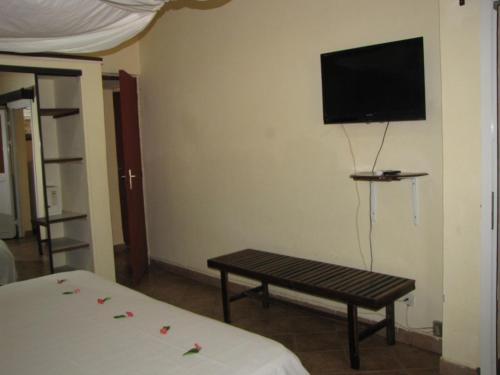 马哈赞加AUX ROCHES ROUGES的一间设有桌子和墙上电视的房间