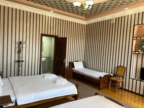 撒马尔罕SHAHNOZA GRAND的酒店客房,设有两张床和镜子