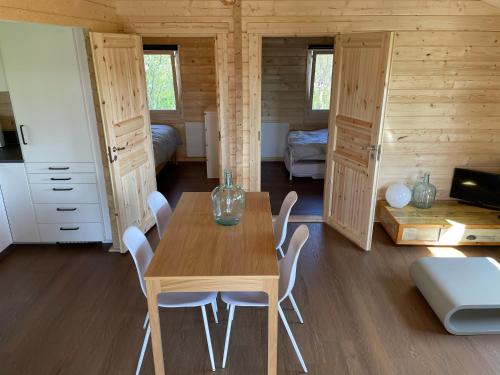 ZwiggelteVakantiehuisje met keuken, 2 slaapkamers en woonkamer的一间带木桌和椅子的用餐室